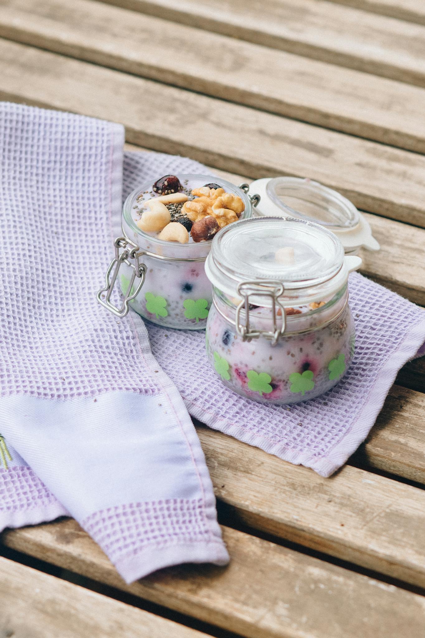 Chia seed pudding in glass jars on a wooden table with a purple cloth.