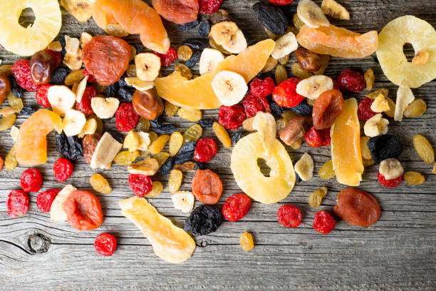 Mix of dried and candied fruit on a wooden background, top view
