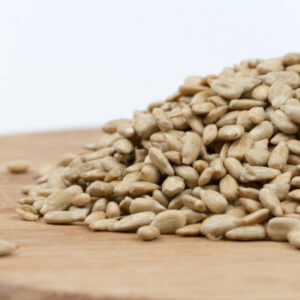 Pile of sunflower seeds on the wooden board.
