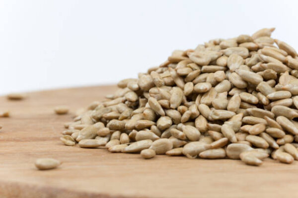 Pile of sunflower seeds on the wooden board.