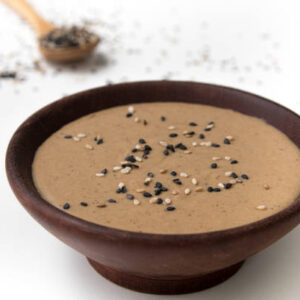 Tahini in a wooden bowl isolated on white background