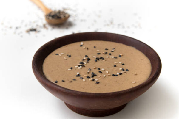 Tahini in a wooden bowl isolated on white background