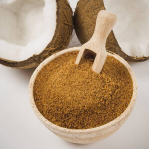 Closeup on a coconut with coconut sugar isolated on white background.