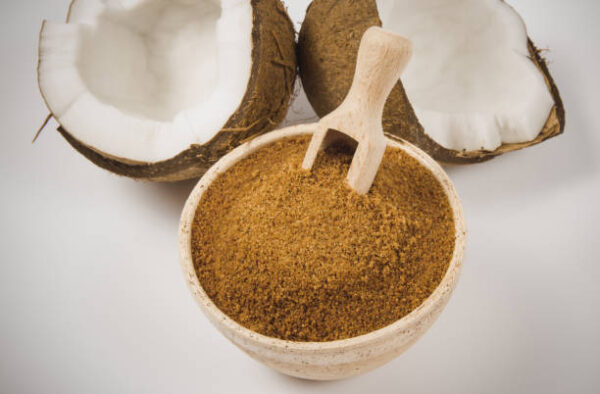 Closeup on a coconut with coconut sugar isolated on white background.
