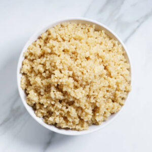 Cooked quinoa in white bowl, top view