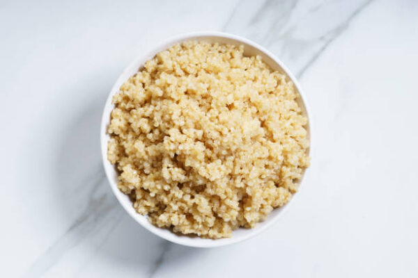 Cooked quinoa in white bowl, top view
